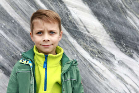 Child on marble wall background in italian quarry, Ruskeala, Kareliaの写真素材