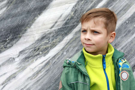 Boy on marble wall background in italian quarry, Ruskeala, Kareliaの写真素材