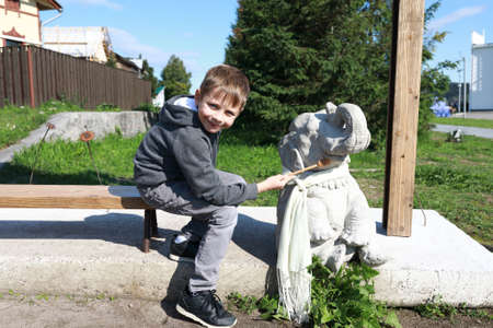 Child posing with sculpture of elephant, Sortavala, Kareliaの写真素材