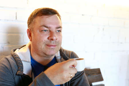 Portrait of man drinking tea in cafeの写真素材