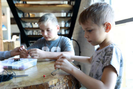 Portrait of boys making bracelets at workshopの写真素材