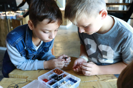Portrait of children making bracelets at workshopの写真素材