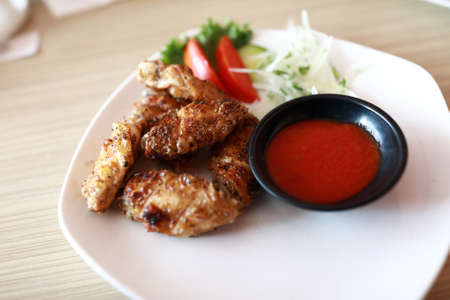 Roasted chicken wings on plate in restaurantの写真素材