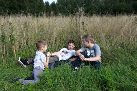Three boys resting on grass in summer, Kareliaの写真素材