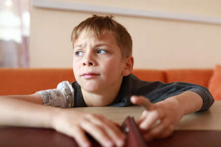 Upset hungry child waiting food in restaurantの写真素材