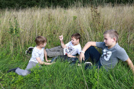 Three children resting on grass in summer, Kareliaの写真素材