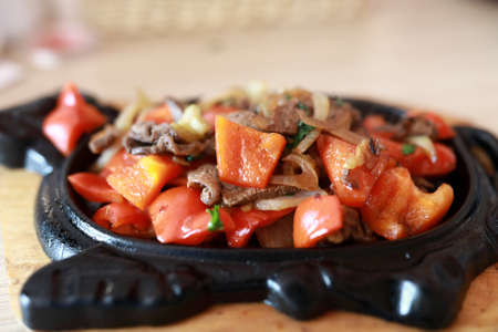 Roasted pork with vegetables in pan in restaurantの写真素材