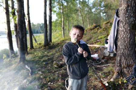 Child eating melon on skewer in forest, Kareliaの写真素材