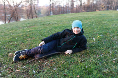 Portrait of child lying on lawn in autumnの写真素材