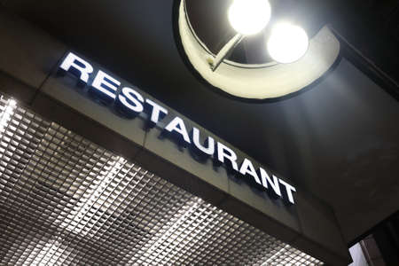 View of glowing restaurant sign board at nightの写真素材