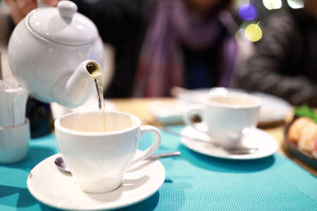 Person pouring herbal tea in a restaurantの写真素材
