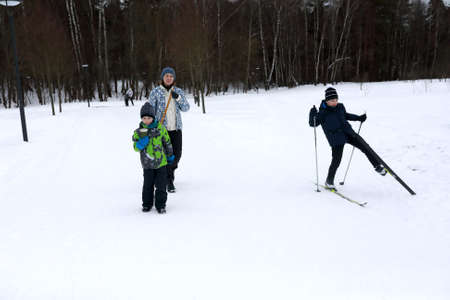 Family walking across snowy field in winterの写真素材