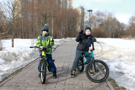 Children with bikes on sidewalk in springの写真素材