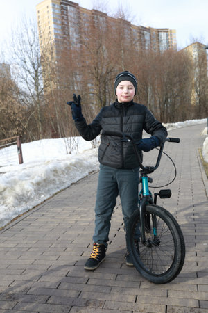 Child with bike on sidewalk in springの写真素材