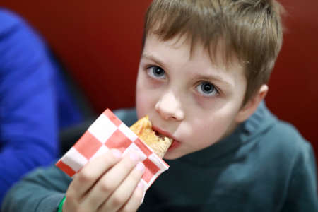 Portrait of a child eating pizza in a restaurantの写真素材