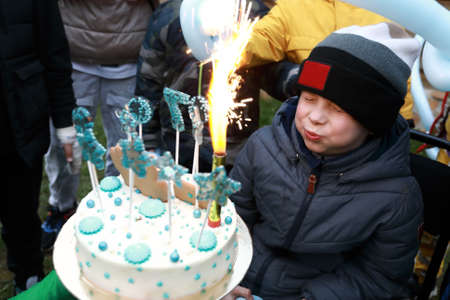 Portrait of child blows out candle on birthday cake