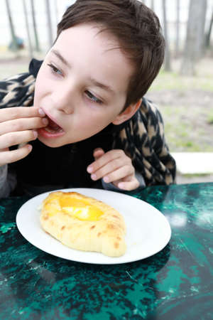 Child eating Adjarian khachapuri in a restaurant