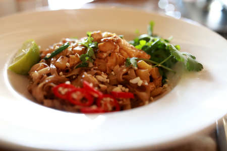 Udon noodles with seafood on plate in restaurant