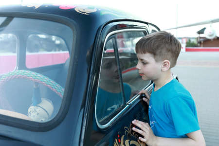 portrait of child looking inside vintage carの写真素材