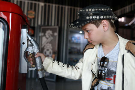 Portrait of boy holding refueling gun in garageの写真素材