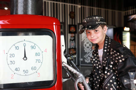 Portrait of kid holding refueling gun in garageの写真素材