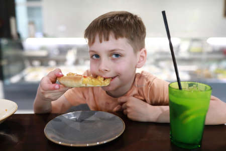 Portrait of a child eating pizza in a restaurantの写真素材
