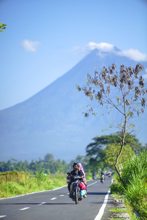 People ride the motorcycle with mount merapi backgroundのeditorial素材