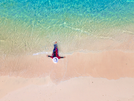 LOMBOK INDONESIA, AUGUST 5 2019 : Aerial view of a woman on the beach lying and sunbathing on pink beach. turquoise water of Pink Beach Lombok, Tourist enjoying summer vacation. Pink beachのeditorial素材