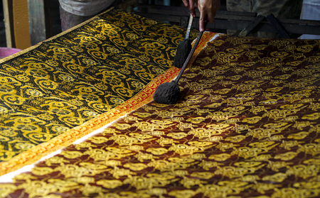 August 11 2019, Surakarta Indonesia : Close Up hand to make batik on the fabric with canting with bokeh backgroundのeditorial素材