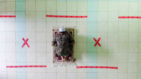 Indonesia April 17 2020 : Social distancing covid 19 young people praying in Mosque Indonesia,...