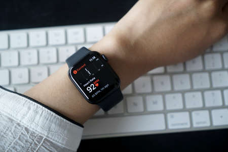 Bali Indonesia June 2, 2020 : Close up hand monitoring Heart Rate on smart watch with keyboard...