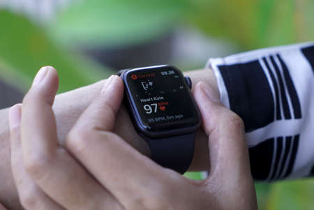 Bali Indonesia June 2 , 2020 : Close up hand monitoring Heart Rate on smart watch with keyboard backgroundのeditorial素材