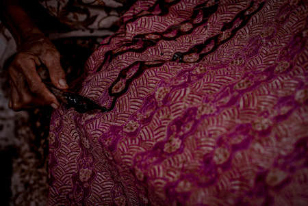 Indonesia June 18, 2020 : Batik, Close Up hand and canting, making Batik Tulis Indonesia. Canting is tool for drawing the texture on the fabric.のeditorial素材