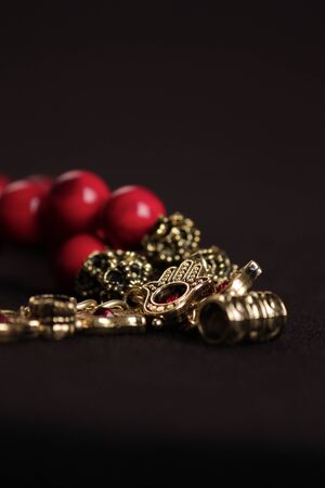 A red stone bracelet with gold and red accessories and a hand-shaped attachmentの写真素材