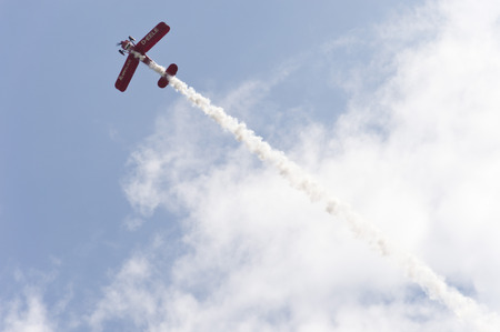 Red airplane under blue and cloudy sky