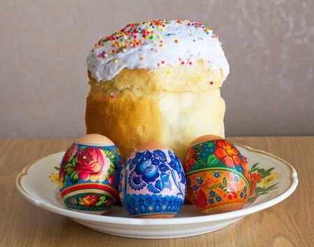 Easter cake and three eggs on the plateの写真素材