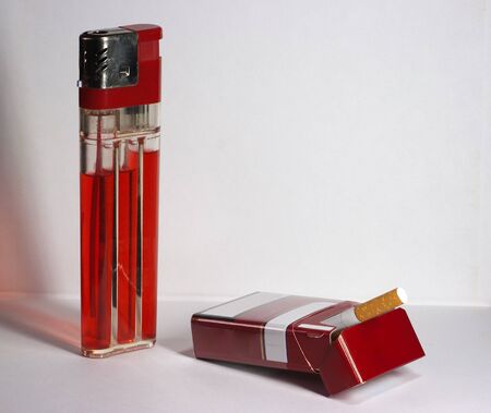 big red lighter and pack of cigarettes on the tableの写真素材