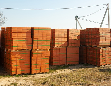 stacks of red bricks for the construction on the construction site outsideの写真素材