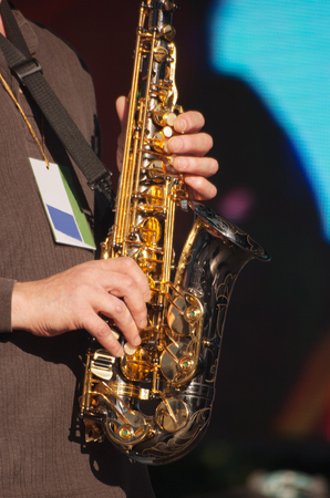 hands of saxophonist in concert outside on summer day closeupの写真素材