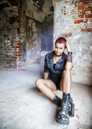 punk girl sitting on the floor in an old abandoned houseの写真素材