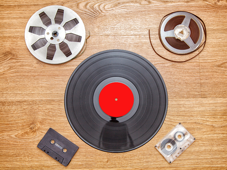vinyl record with cassetes and reel tape lying onthe floorの写真素材