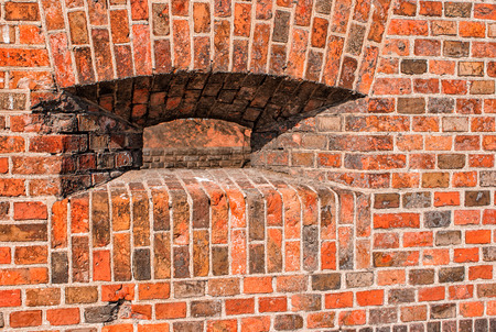 loophole in the wall with red bricks of the old fortress