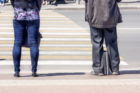 pedestrians waiting to cross street on sunny summer dayの写真素材