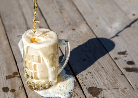 glass mug with beer on the table in the park on sunny summer dayの写真素材