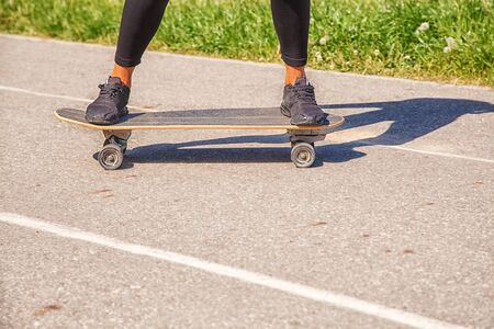 young woman skateboarding in the park on sunny summer day. legs closeupの写真素材