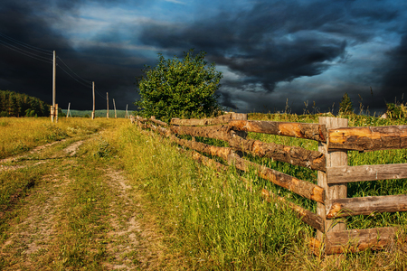 rural landscape with a dark gloomy stormy sky on summer dayの写真素材