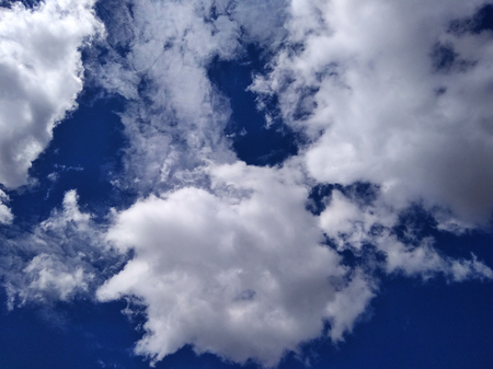 white clouds flying in the bright blue sky on sunny summer dayの写真素材