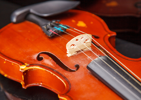 brown vintage violin lying on a table closeup indoorの写真素材