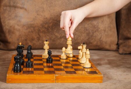 mom and daughter play chess at home. coronavirus quarantine. hand closeup