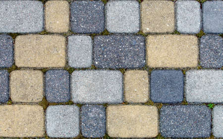 road paved with sidewalk tiles. beautiful brick background with, masonry texture of yellow light and dark gray bricks. outdoor closeupの写真素材